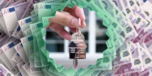 Ključ u ruci sa novčanicama u pozadini