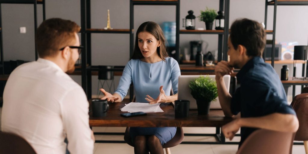 Troje ljudi za stolom pregovara