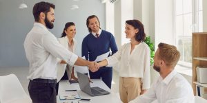 Dvoje ljudi se rukuje u agenciji za prodaju nekretnina