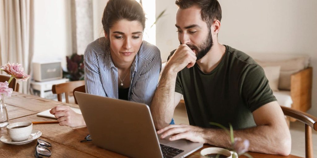 Mlađi par gleda u ekran laptopa